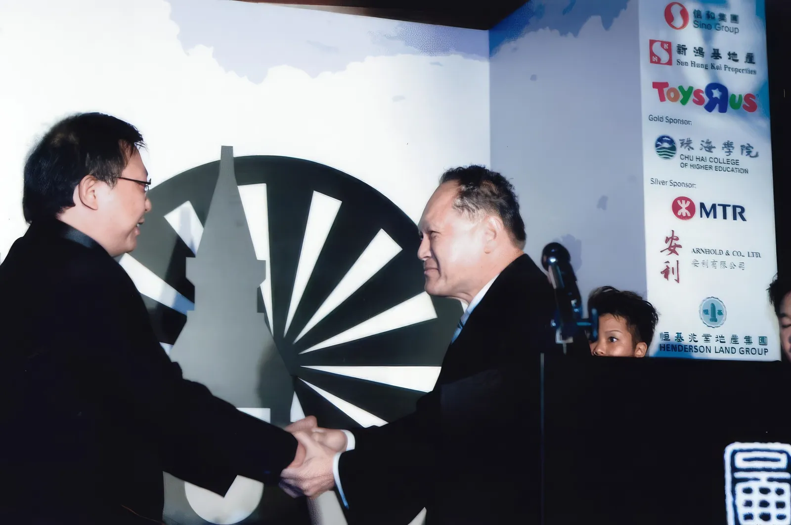 Dr. Cecil Chao congratulating the winner of a contest.
