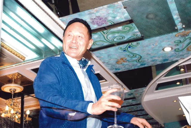 A portrait of Dr. Cecil Chao at his home during an event.