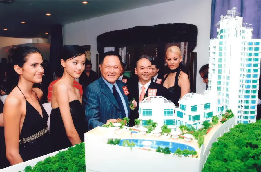 Fashion models with the architectural model of One Kowloon Peak.